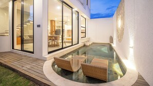 A modern house with a glass-enclosed patio, a hot tub, and wicker furniture. - Modern 2BR Villas • Stylish Stay in Central Canggu (Canggu)