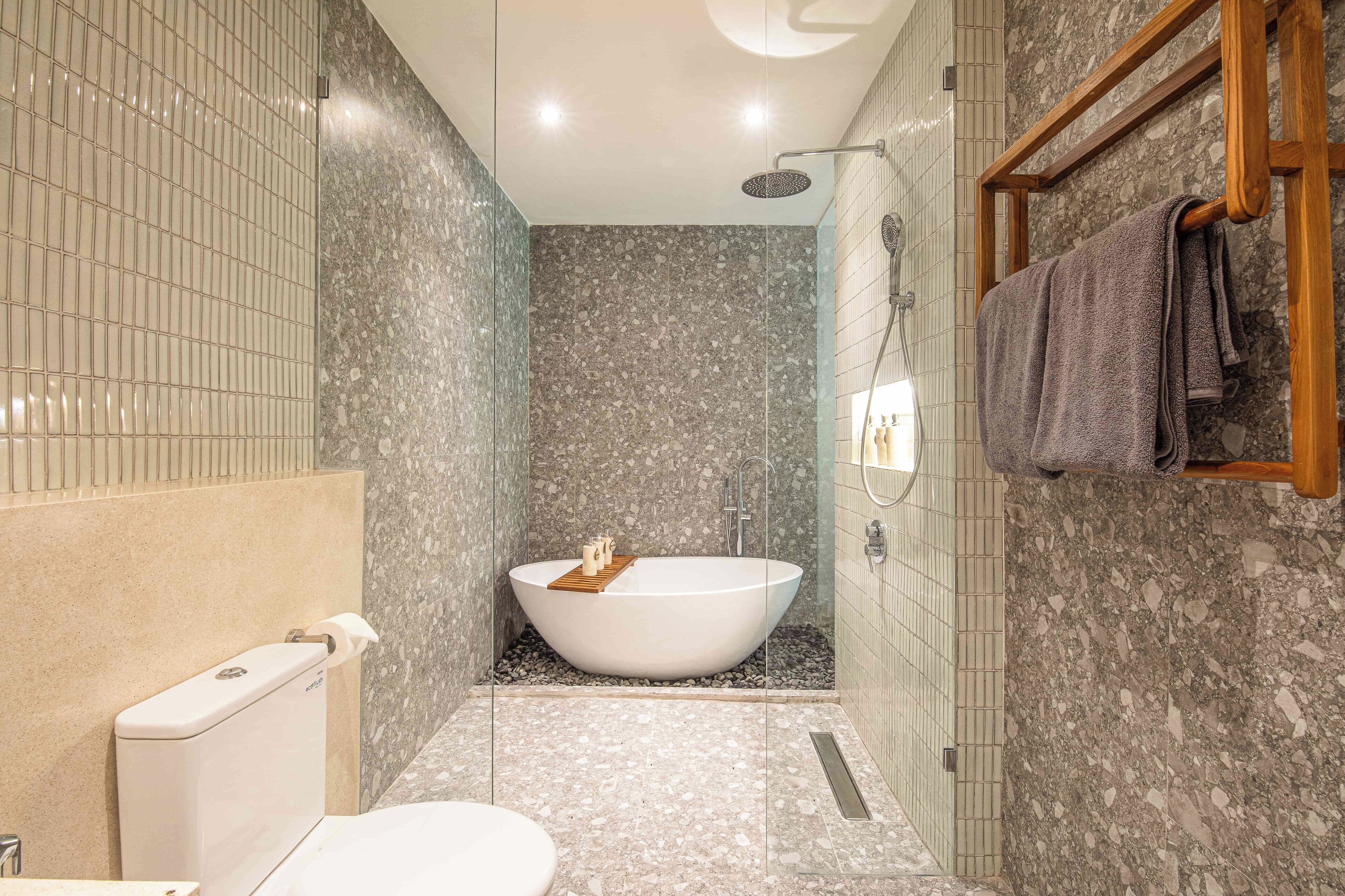 Un baño moderno con una bañera independiente, un inodoro y una zona de ducha.