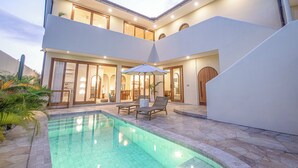 A modern two-story house with a swimming pool, outdoor seating, and a well-lit interior. - Chic Villa Living, Hidden in the Calm of Tumbak Bayuh (Canggu)