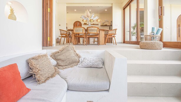 A modern living room with a grey sofa, wooden chairs, and a dining area in the background. - Chic Villa Living, Hidden in the Calm of Tumbak Bayuh (Canggu)