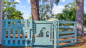 A blue gate with a number '345' and a sign that reads 'Security Camera in use'.