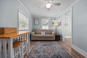 A cozy living area with a wooden bar, a beige sofa, and a patterned rug.