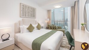Una moderna camera d'hotel con un letto grande, un divano, una scrivania e vista sulla città.