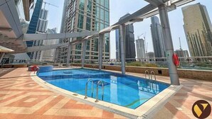 Una piscina sul tetto con vista su moderni grattacieli.