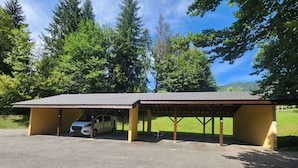 A covered parking area with a white car parked inside. - Quiet T3 in Samoëns, near center, WIFI, private parking (Samoëns)