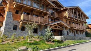A multi-story wooden lodge with balconies and stone foundations.