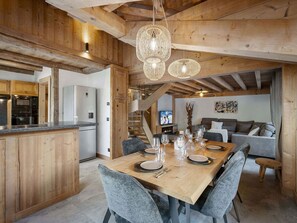 Interior em madeira com sala de jantar, cozinha e área de estar.