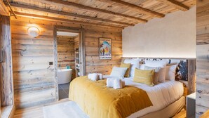 Ein Schlafzimmer in einer Holzhütte mit einem Bett, einem Badezimmer und einem Poster an der Wand.
