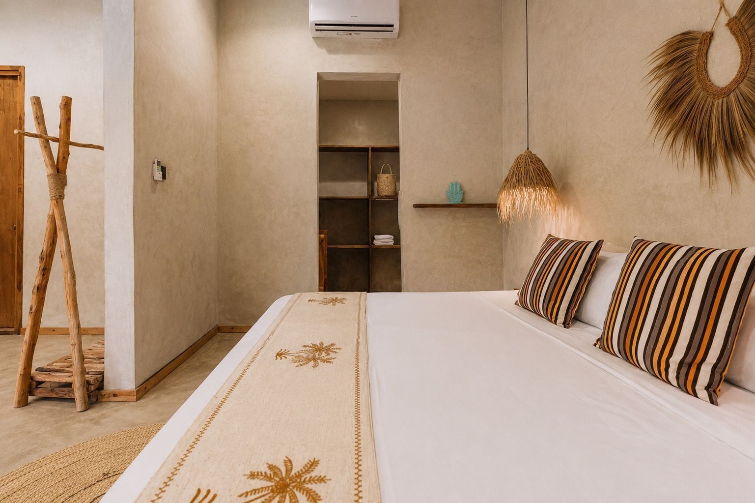 A bedroom with a bed, a wooden ladder, a shelf with decorative items, and a hanging light fixture.