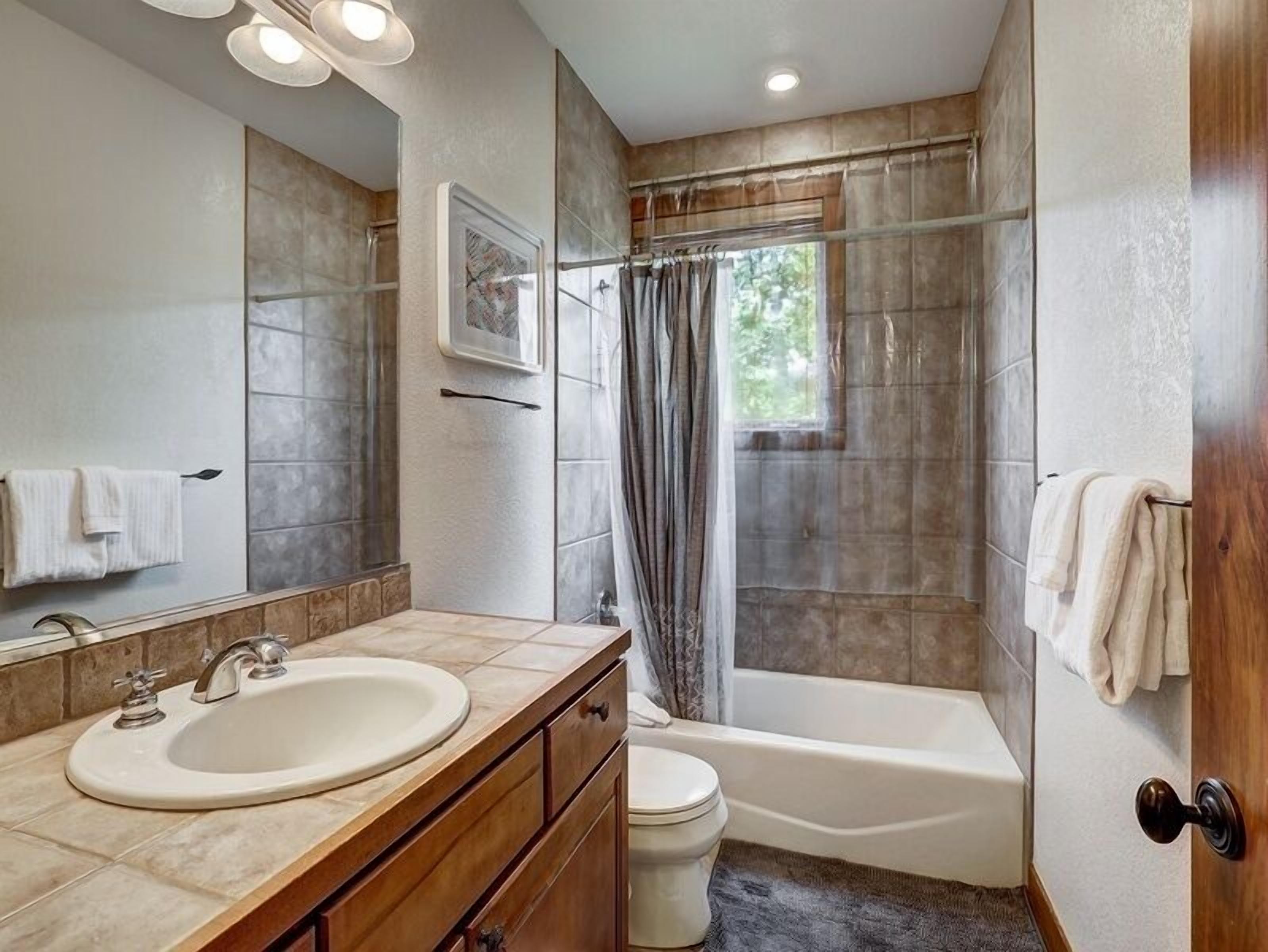 Une salle de bain moderne avec un grand lavabo, un meuble-lavabo, des toilettes et une baignoire.