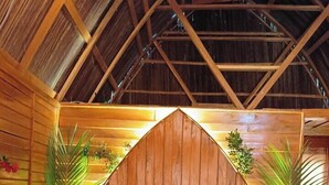 Une pièce chaleureuse en bois, avec un lit, un banc et des plantes en pot.
