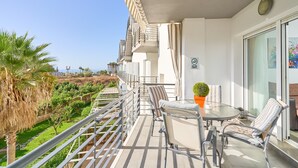 A balcony with a glass table, chairs, and a potted plant. - Apartment 'Sea and Mountain Views' with Sea View, Shared Pool, and AC (Torrox)