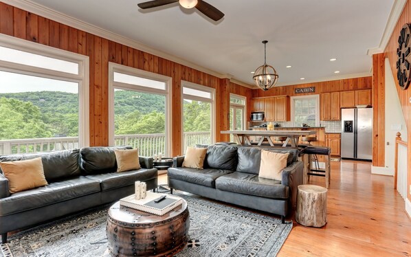 A spacious living room with a large sectional sofa, a coffee table, and a view of the outdoors.