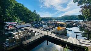 Een jachthaven met verschillende boten die afgemeerd liggen, omringd door weelderige begroeiing en een heldere lucht.