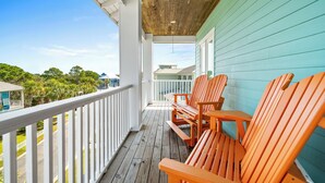 A wooden deck with a railing, two wooden chairs, and a table. - R&R in Kiva house at Kiva Dunes (Gulf Shores)