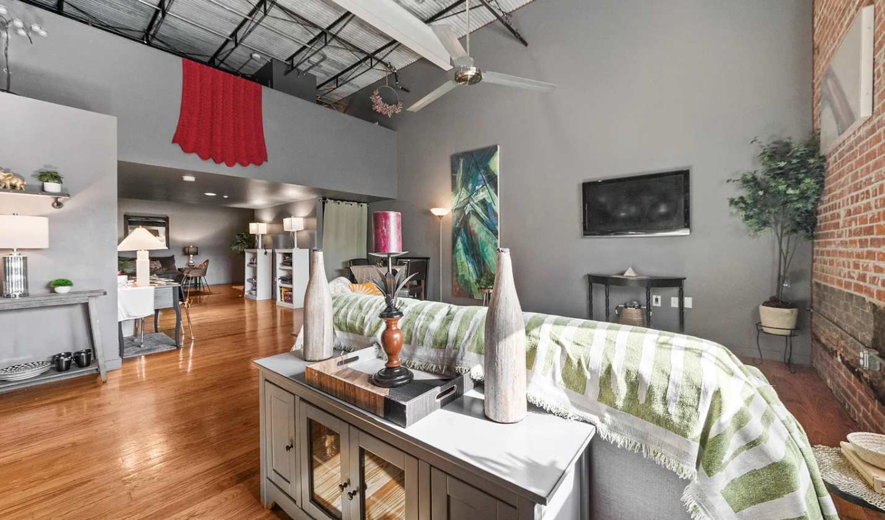 Una habitación amplia con una cama grande, un escritorio y una zona de comedor.
