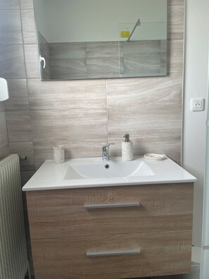 Regadera, secadora de cabello, toallas, papel de baño 