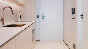 A modern kitchen with a wooden countertop, a copper faucet, and recessed lighting. - Viana Home Design Studio in Pinheiros (São Paulo)