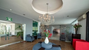 A modern lobby with a chandelier, seating areas, and a reception desk. - Family-Friendly Double Room Escape in Mérida with Pool, Terrace & Cozy Comfort (Mérida)
