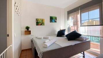 Tabla de planchar con plancha y ropa de cama