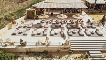 Um clube de praia com espreguiçadeiras e guarda-sóis, acesso livre e estacionamento.