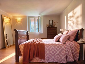 A bedroom with a wooden bed, a dresser, a mirror, and a window with shutters. - Casale Bera, hills view, private pool and garden (Cossano Belbo)