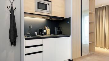 Una cocina moderna con microondas integrado, un lavabo y una botella de vino.