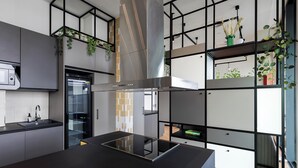 A modern kitchen with a black and yellow countertop, a stainless steel range hood, and a built-in oven.