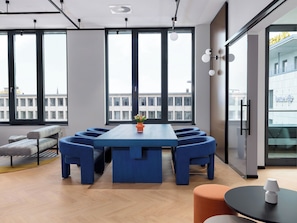 A modern conference room with a long table, blue chairs, and a vase of flowers. - smartments Bielefeld Hauptbahnhof (Bielefeld)