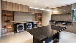 A modern kitchen with built-in appliances, wooden shelving, and a herringbone-patterned backsplash. - Linea Home (São Paulo)
