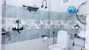 A bathroom with a toilet, sink, and towel rack. - Luxury Studio Apartment at Noida (Noida)