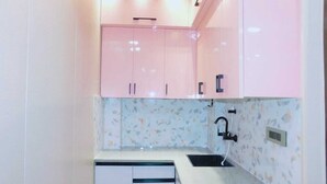 A compact kitchen with a sink, countertop, and cabinets. - Luxury Studio Apartment at Noida (Noida)