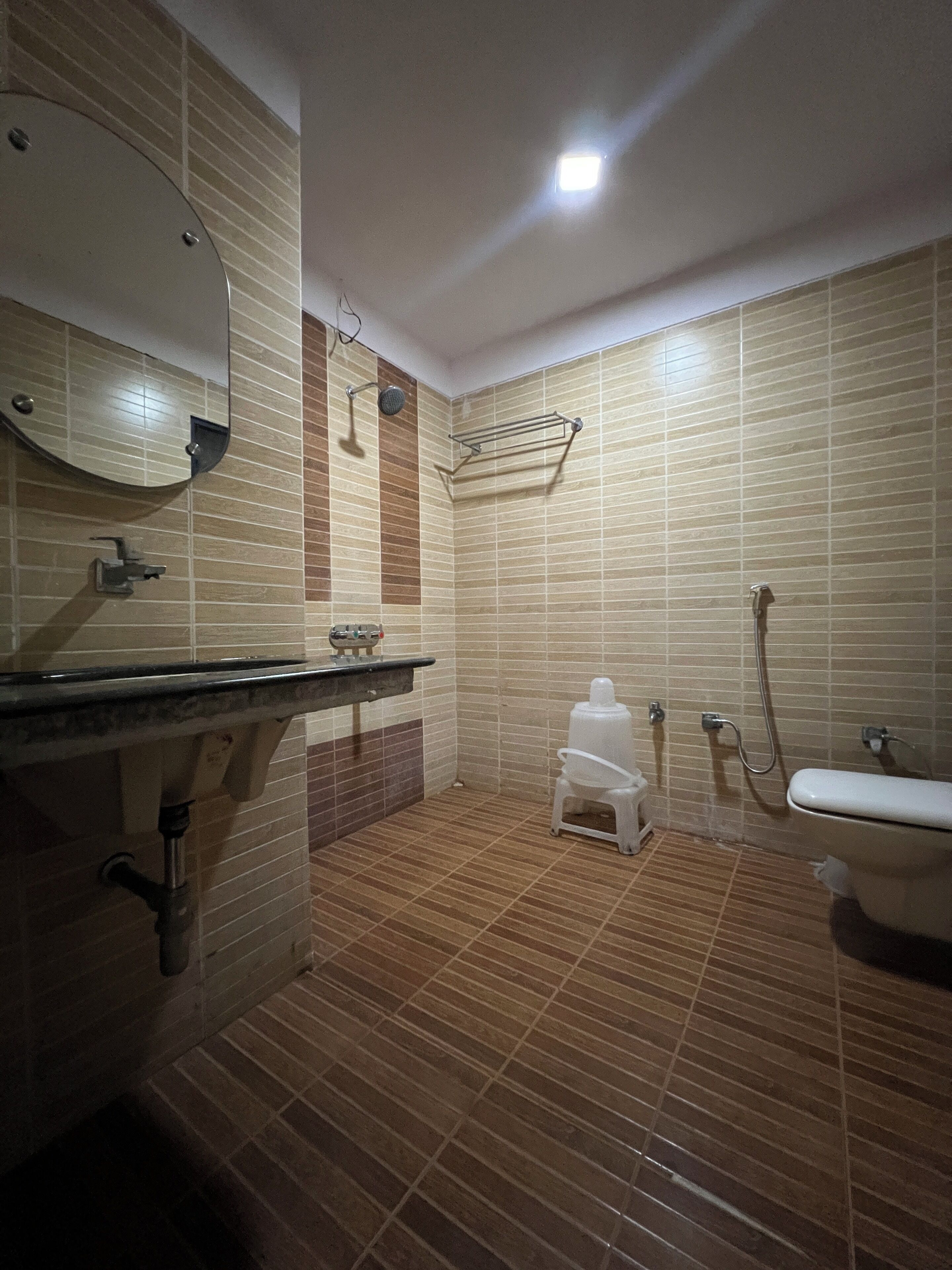 A bathroom with a sink, mirror, shower, and toilet.