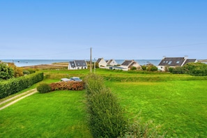 Un village côtier avec des maisons, un ciel dégagé et une vue sur la mer.