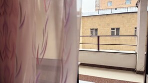 Näkymä parvekkeelta, jossa on laatoitettu lattia ja kaide.