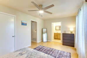 Ein Schlafzimmer mit Deckenventilator, einem großen Spiegel, einem Schminktisch und einem Teppich.