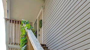 Eine Holztreppe mit Handlauf, die zu einer Tür mit Fenster führt.