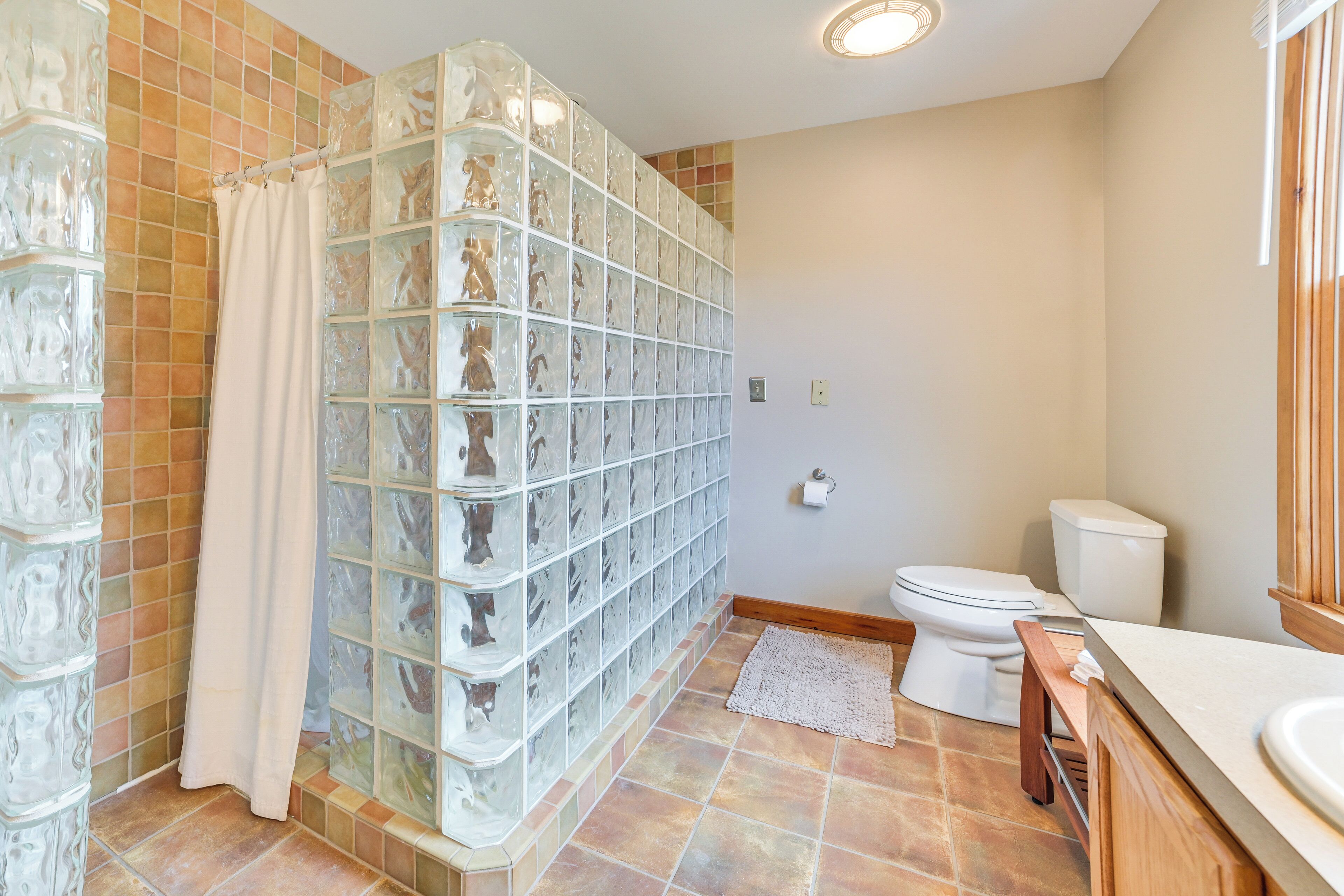 Ein Badezimmer mit Duschkabine, Toilette und Waschbecken.
