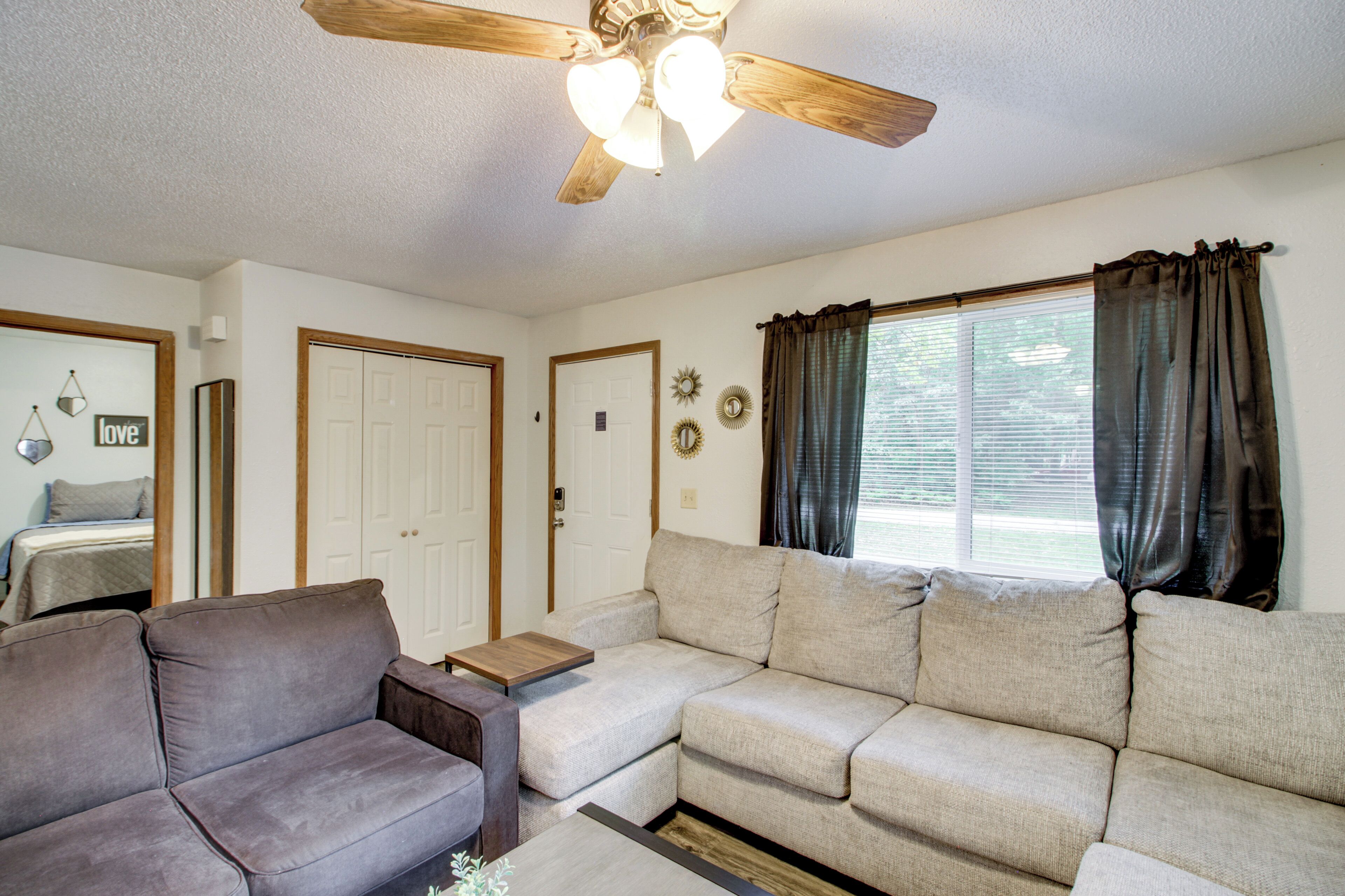 A living room with a sofa, a coffee table, and a ceiling fan.