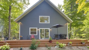 A two-story house with a covered porch, a grill, and outdoor seating. - Paddle, Play & Relax: Home w/ Pioneer Lake Access! (Conover)