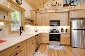 Una cucina moderna con mobili in legno, elettrodomestici in acciaio inossidabile e una finestra vista alberi.