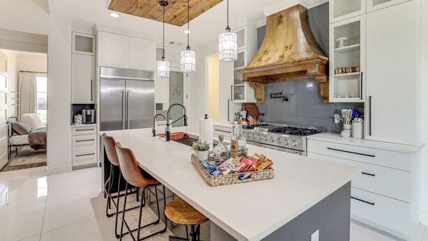 A modern kitchen with a central island, stainless steel appliances, and wooden accents. - Luxe Retreat w/ Patio & Fenced Yard in Waxahachie! (Waxahachie)