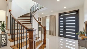 A modern staircase with wooden steps and metal railings, leading to an upper floor. - Luxe Retreat w/ Patio & Fenced Yard in Waxahachie! (Waxahachie)