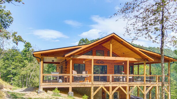 A wooden cabin with a balcony, surrounded by trees and a clear sky. - Amazing Waterfall! New Scenic Black Mtn Log Cabin (Black Mountain)