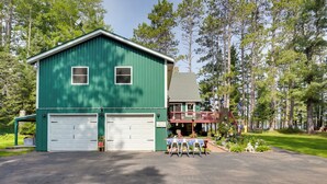 A two-story house with a green exterior and a white garage door. - Lakefront Family Home w/ Dock, Views: Pet-friendly (Conover)