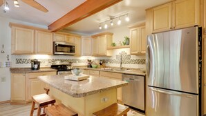 A kitchen with wooden cabinets, a stainless steel refrigerator, a microwave, and a granite countertop. - Lakefront Family Home w/ Dock, Views: Pet-friendly (Conover)