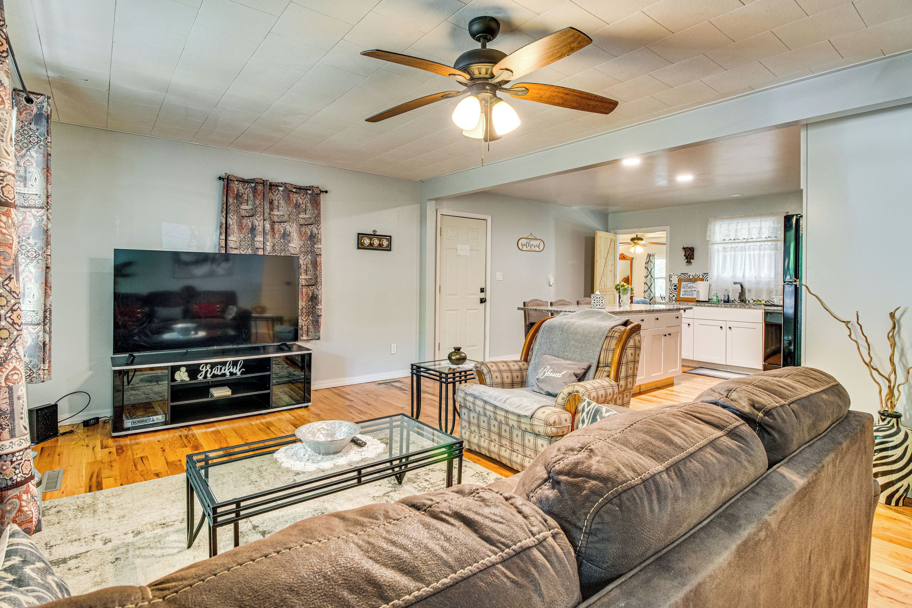 A living room with a sofa, TV, and ceiling fan.