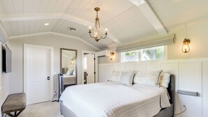A spacious bedroom with a large bed, a sitting area, and a television. - Pool & Stunning Water Views: Kent Island Home! (Stevensville)