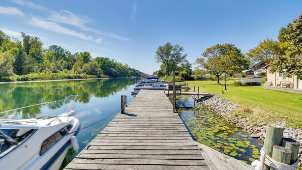 A wooden dock extending into a calm river with boats docked on the left. - Riverfront Couple's Retreat, 3 Mi to Seneca Lake! (Waterloo)