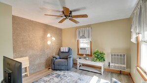 A living room with a ceiling fan, a TV, a recliner, a sofa, a coffee table, and a radiator. - Riverfront Couple's Retreat, 3 Mi to Seneca Lake! (Waterloo)